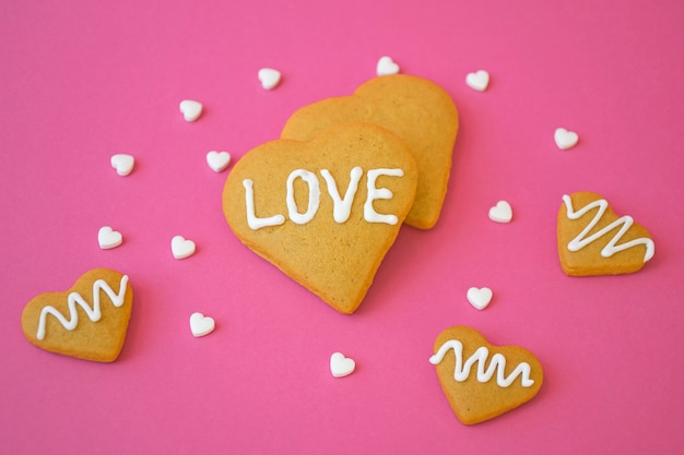 San Valentino, biscotti di pasta frolla fatti in casa a forma di cuore con messaggio LOVE e confetti di caramelle bianche. Concetto di amore e romanticismo