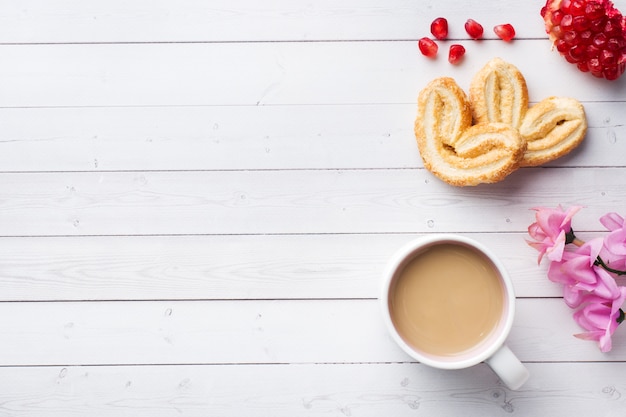 San Valentino Colazione concetto. Cuori dei biscotti e della tazza di caffè su una tavola bianca. copia spazio, disteso.