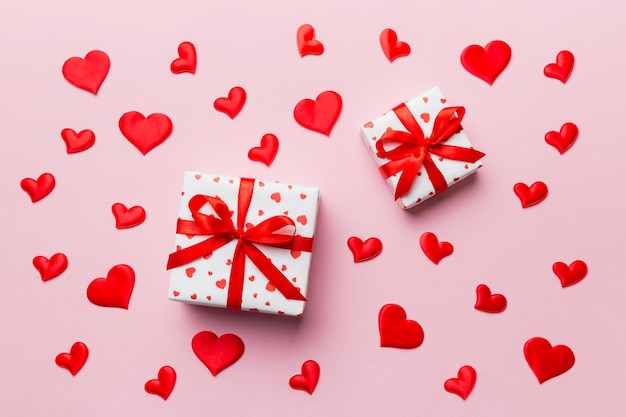 San Valentino composizione Sfondo: confezione regalo rossa con fiocco e cuore. Regalo di Natale. Vista dall'alto. Biglietto di auguri per le feste.