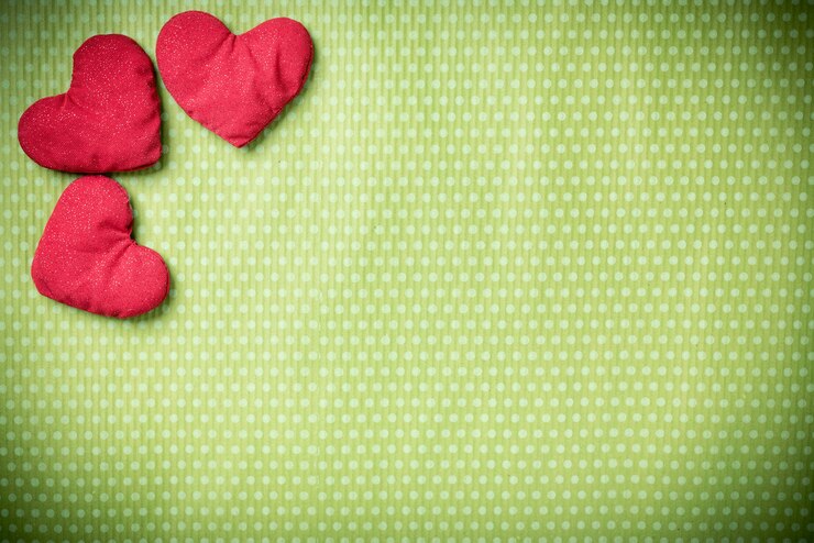Foto san valentino. cuori lavorati a maglia colorati su un'annata verde a pois. cuore rosso.
