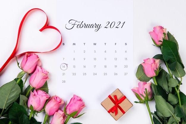 San Valentino febbraio calendario anello di diamanti regalo cuore rosso e rose rosa su bianco