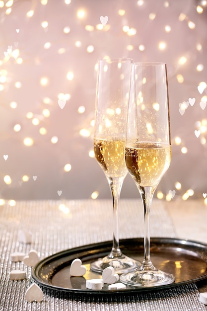 San Valentino o biglietto di auguri di matrimonio con due bicchieri di champagne sul vassoio in piedi