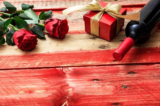 San Valentino Rose bottiglia di vino rosso e un regalo su sfondo di legno