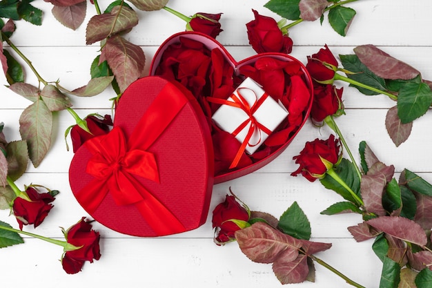 San Valentino. Rose rosse e contenitore di regalo sulla tavola di legno