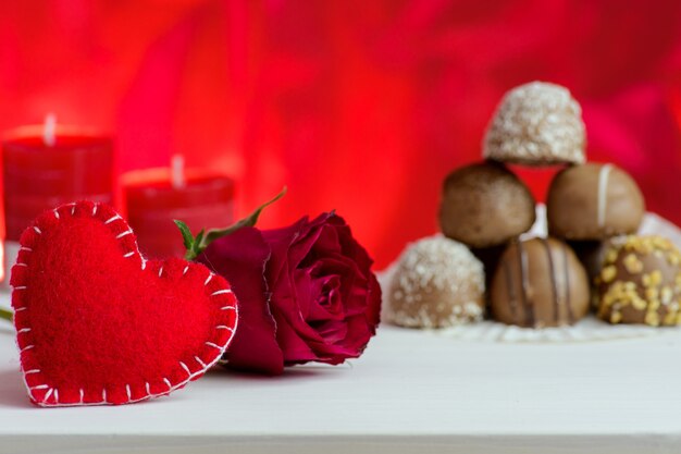 San Valentino sfondo rosso con rose e cioccolato.