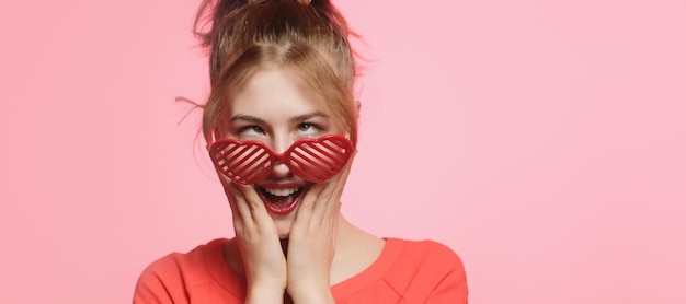 San Valentino super vendita banner Divertente giovane donna in occhiali a forma di cuore su sfondo rosa