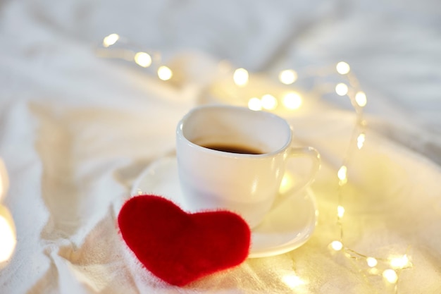 San Valentino Tazza di caffè a letto con cuori rossi e luci copia spazio Biglietto di auguri colazione romantica