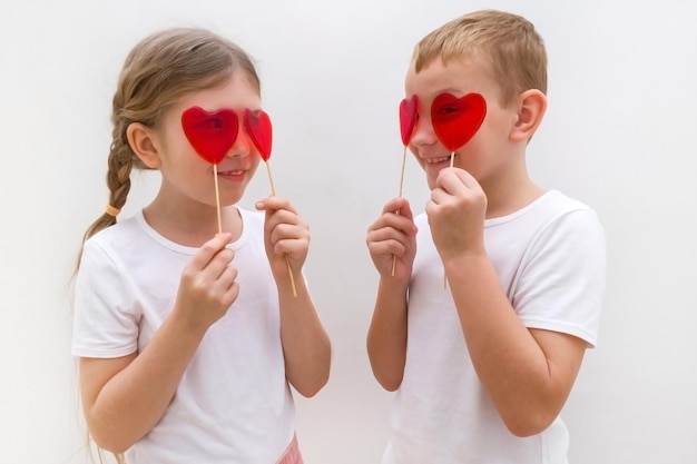 San Valentino Un ragazzo e una ragazza mangiano lecca-lecca Caramello rosso a forma di cuore