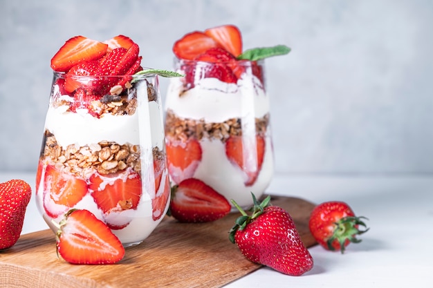 Sana colazione a base di semifreddi alla fragola fatti con yogurt alla fragola fresco e muesli in bicchieri