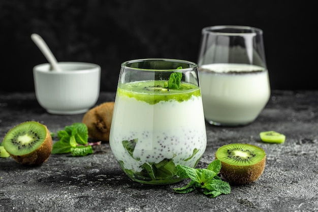 Sana colazione budino di chia con kiwi in vasetti di vetro sul tavolo scuro Pulire mangiare dieta vegano concetto di cibo banner menu ricetta luogo per il testo