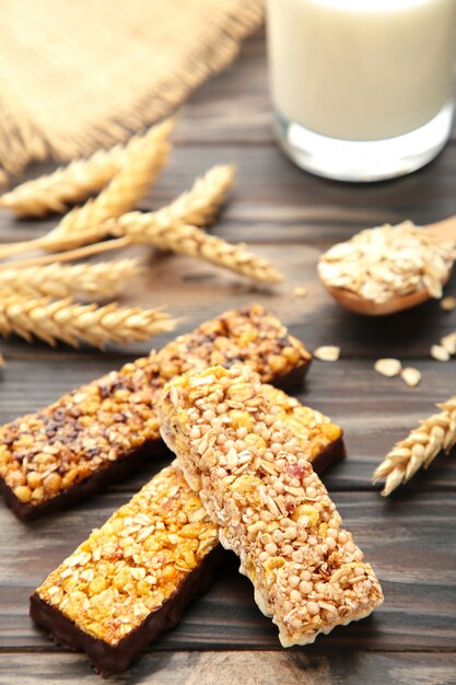 Sana colazione con barrette di cereali e latte sul tavolo di legno marrone.