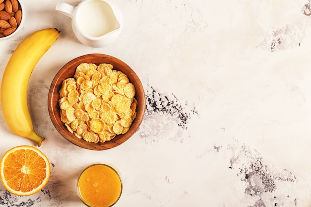 Sana colazione con ciotola di muesli, bacche e frutta, noci, succo d'arancia, latte