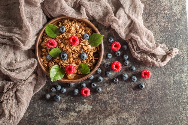 Sana colazione con muesli e frutti di bosco su sfondo scuro