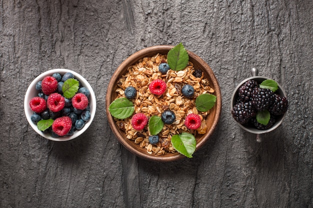 Sana colazione con muesli e frutti di bosco su sfondo scuro