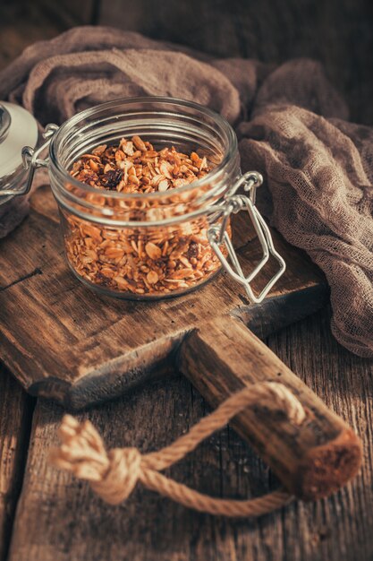 Sana colazione con muesli in ciotola di vetro su sfondo scuro