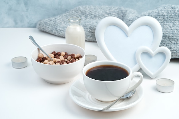 Sana colazione con una cornice con cuori e candele su bianco