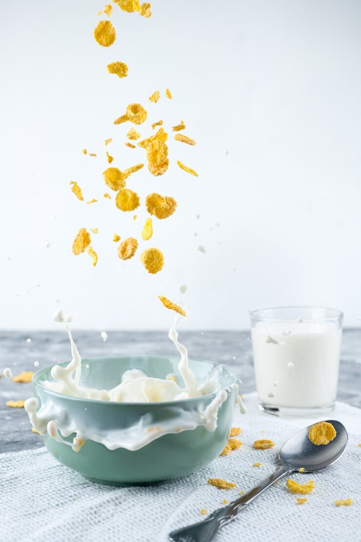 Sana colazione-cornflakes e spruzzi di latte su sfondo blu.