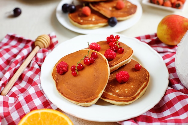 Sana colazione estiva, pancake americani classici fatti in casa con bacche fresche e miele