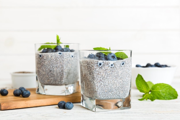 Sana colazione o mattina con semi di chia budino alla vaniglia e bacche di mirtillo su sfondo tavolo dieta vegetariana e concetto di salute Budino di chia con latte di cocco e mirtillo