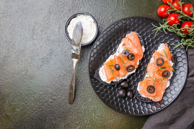 Sana colazione panino al salmone con crema di formaggio e pane nero su oscurità