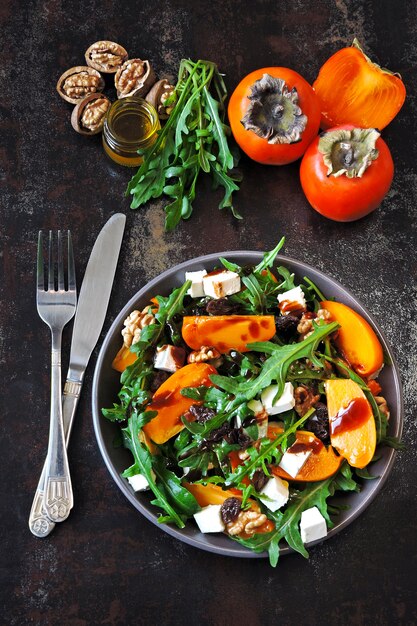 Sana insalata con cachi, rucola, noci e formaggio feta.