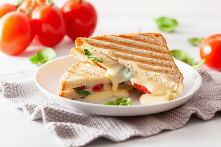 Foto sandwich al formaggio alla griglia e al pomodoro su sfondo bianco