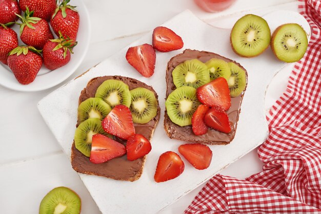 Sandwich alla frutta, fragole e kiwi. Toast al burro di arachidi.