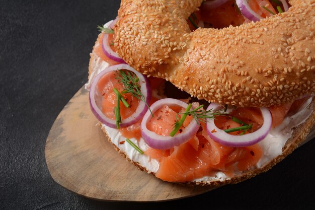 Sandwich bagel con salmone, crema di formaggio, cetriolo e cipolle