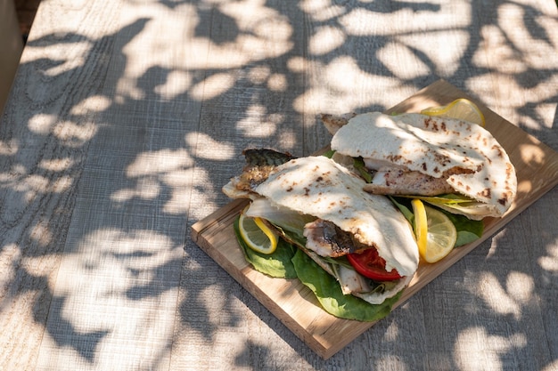 Sandwich balik ekmek con filetto grigliato di sgombro pomodori cipolle e lattuga