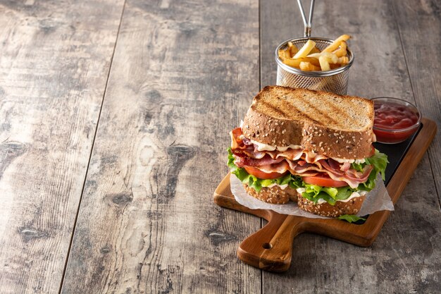 Sandwich BLT con pancetta, lattuga e pomodoro sulla tavola di legno