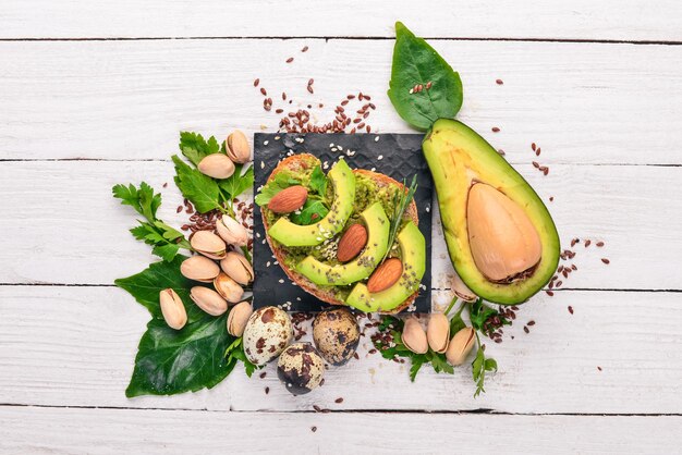 Sandwich con avocado e mandorle su sfondo di legno Vista dall'alto Spazio libero per il testo