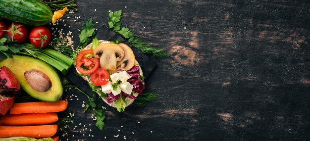 Sandwich di hamburger con funghi di formaggio feta e foglie di lattuga su uno sfondo di legno Vista dall'alto Spazio di copia