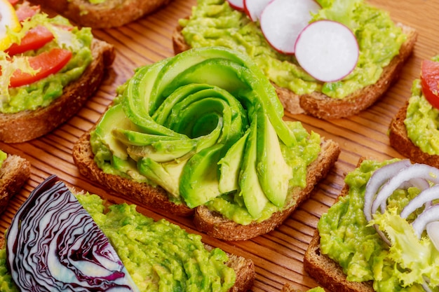 Sandwich di pane tostato fatto in casa con avocado e marmellata sul cibo sano di tavola di legno