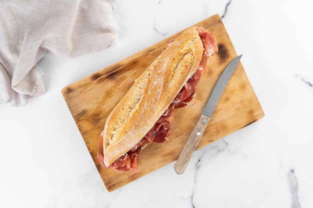 Sandwich di prosciutto serrano spagnolo su sfondo di marmo