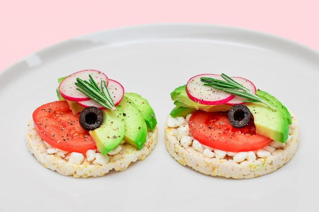 Sandwich di torta di riso con ricotta di avocado, pomodoro, olive e ravanello