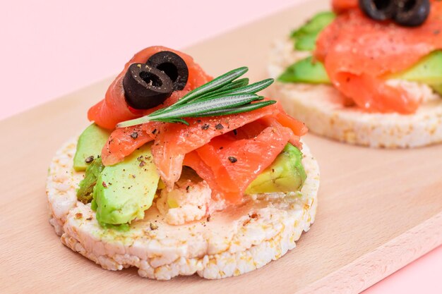 Sandwich di torta di riso con salmone fresco, avocado e olive