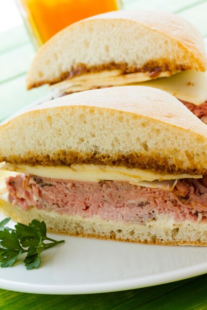 Sandwich gourmet di roast beef con patatine sul lato.