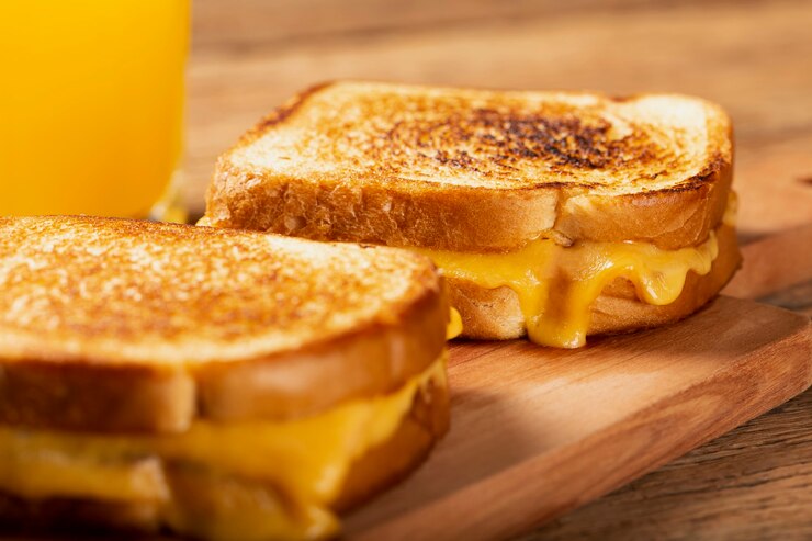 Photo sandwich ham dan keju panggang dengan keju dan ham di atas panggangan