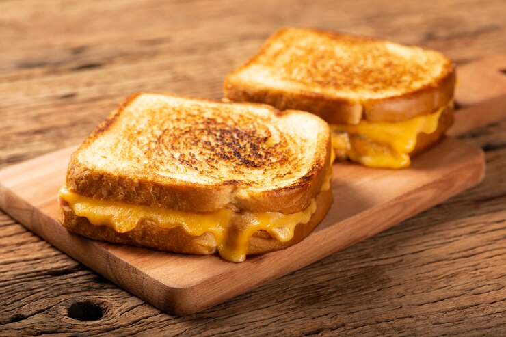 Photo sandwich ham dan keju panggang dengan keju dan ham di atas panggangan