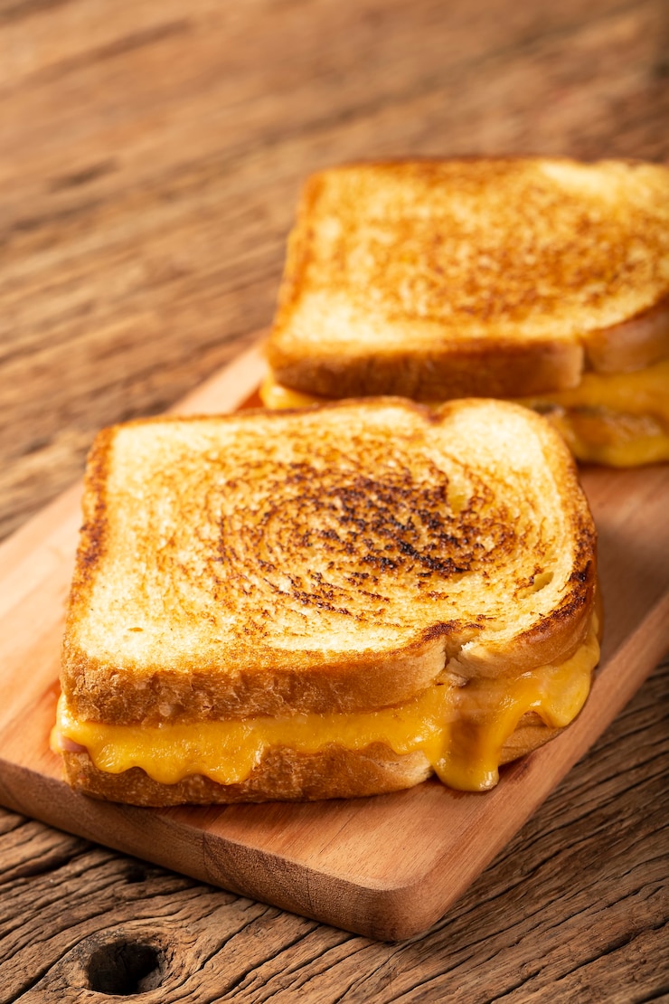 Photo sandwich ham dan keju panggang dengan keju dan ham di atas panggangan