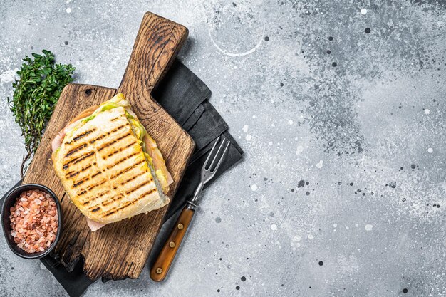 Sandwich Panini tostato con prosciutto e formaggio Sfondo grigio vista dall'alto copia spazio