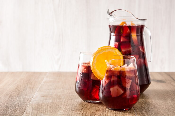 Foto sangria del vino rosso in vetro sulla tavola di legno