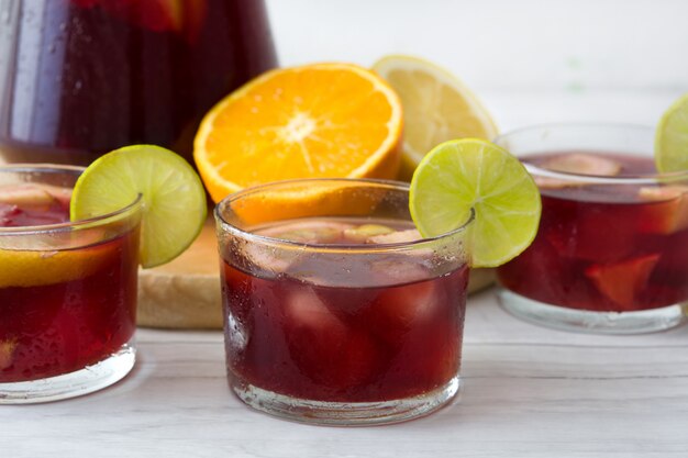 Sangria di estate in vetro sulla tavola di legno bianca