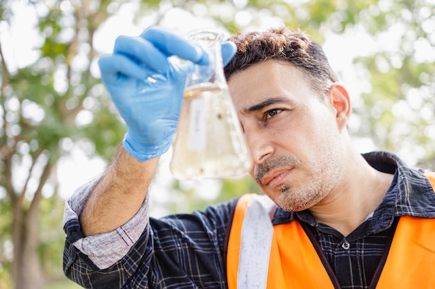 Sanitario e medico scienziato o biologo controllano il campione di acque reflue nella zona industriale