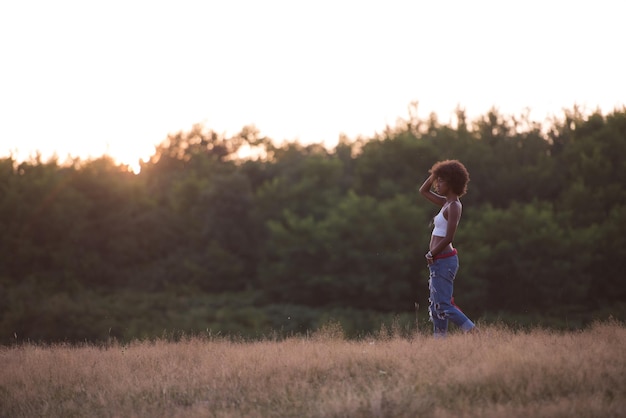 Sano cercando sorridente giovane donna afroamericana bella serata estiva in natura