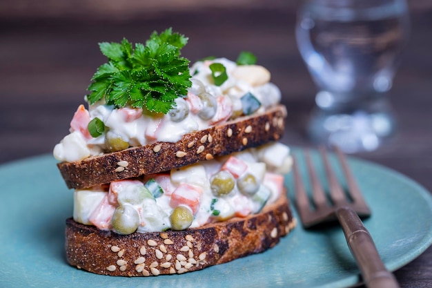 Sano panino doppio fatto in casa con insalata olivier in piatto pronto da mangiare cibo ucraino