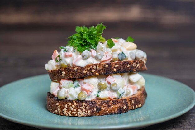 Sano panino doppio fatto in casa con insalata olivier in piatto pronto da mangiare cibo ucraino