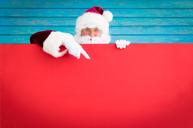 Santa Claus che tiene bandiera in bianco. Cartolina d'auguri di buon Natale. Concetto di vacanza di Natale