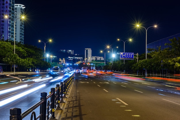 Sanya, Hainan, Cina - 25 gennaio 2020: Vista notturna della città di Sanya con edifici luminosi multicolori, strutture, strade, marciapiedi, pali, ponti.