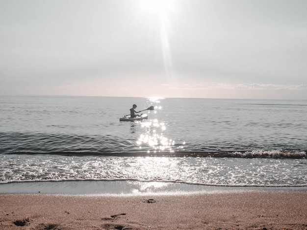 Sap surfer boy sul mare in una limpida giornata estiva